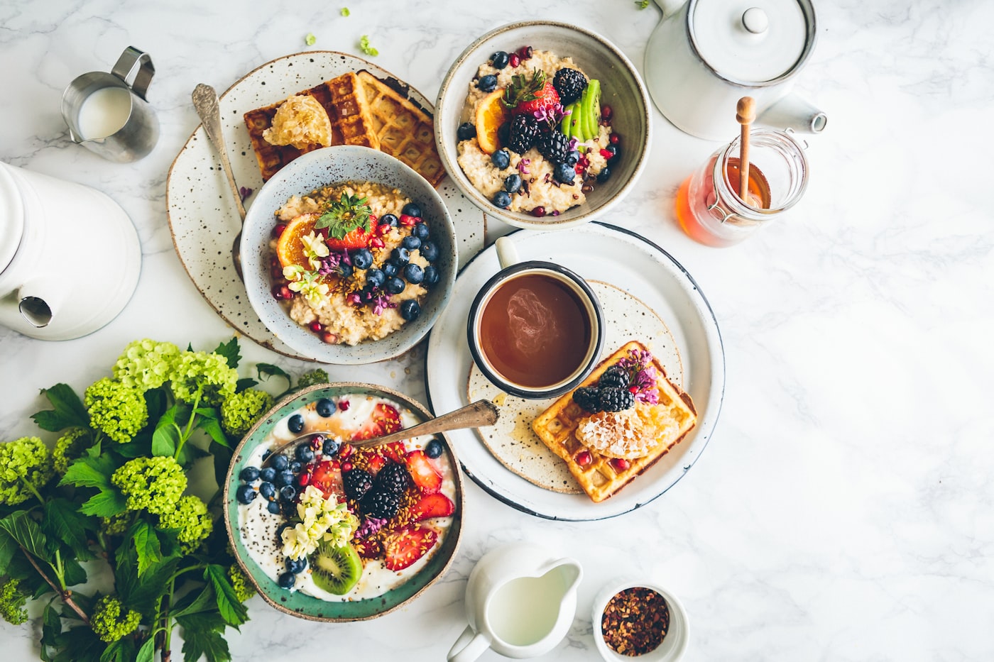 A brunch table crowded with waffles, berries and coffee